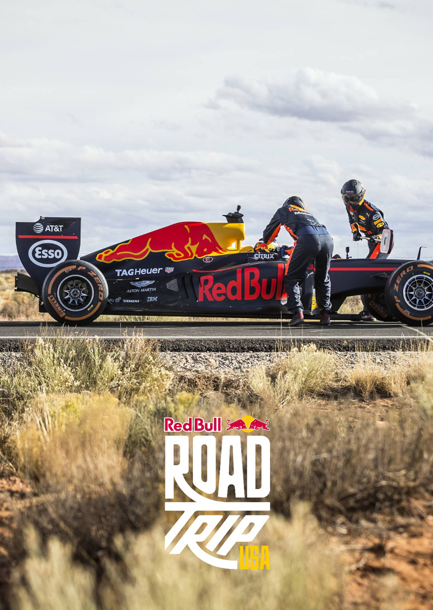 Red Bull Road Trip USA logo on a photo of Red Bull Road Trip USA pit crew servicing the F1 race car in the desert
