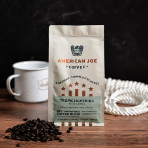 American Joe Coffee bag sitting on a table surrounded by a coffee cup and beans