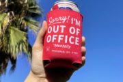 Out of Office Koozie by Hoodzpah in front of palm tree
